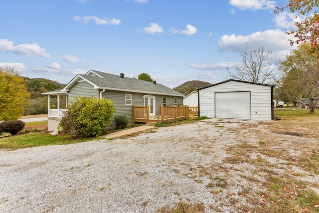 view of front of home with a deck, a garage, and an outdoor structure