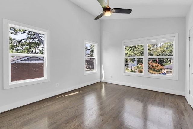 unfurnished room with ceiling fan, plenty of natural light, dark wood-type flooring, and vaulted ceiling