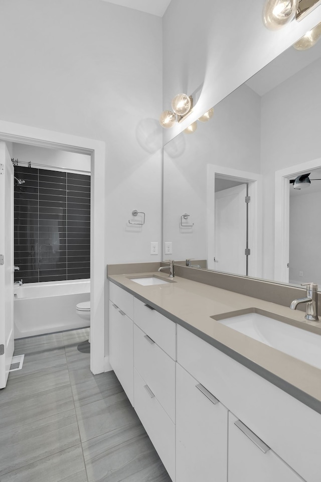 full bathroom with tile patterned flooring, shower / tub combination, vanity, and toilet