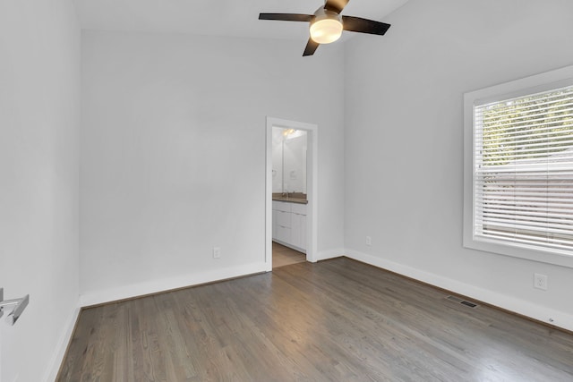 empty room with lofted ceiling, hardwood / wood-style floors, and ceiling fan