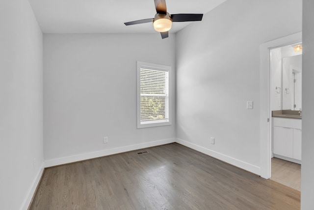 spare room with wood-type flooring, vaulted ceiling, sink, and ceiling fan