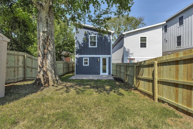 rear view of property with a lawn and a patio