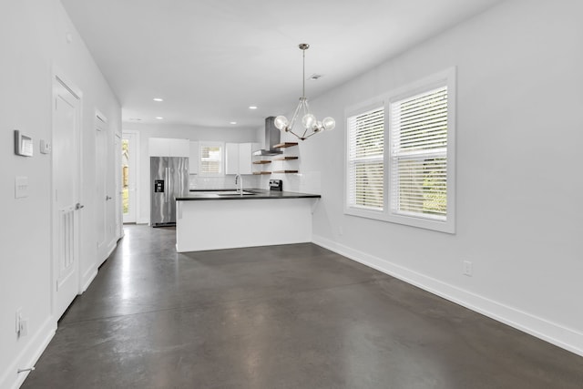 kitchen featuring white cabinets, hanging light fixtures, wall chimney exhaust hood, backsplash, and stainless steel fridge with ice dispenser