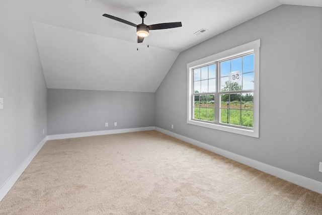 additional living space featuring vaulted ceiling, light colored carpet, and ceiling fan