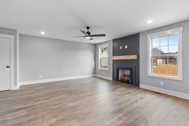 unfurnished living room featuring light hardwood / wood-style flooring, a fireplace, and plenty of natural light