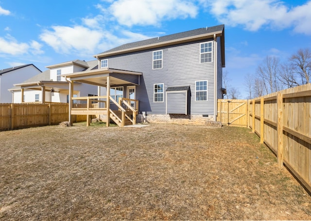 rear view of property with a wooden deck and a lawn