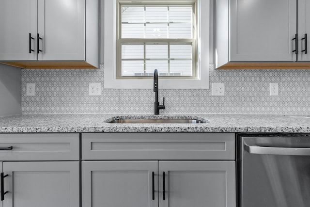 kitchen with sink, gray cabinets, light stone countertops, and dishwasher