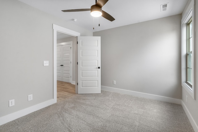 carpeted empty room featuring ceiling fan and a healthy amount of sunlight