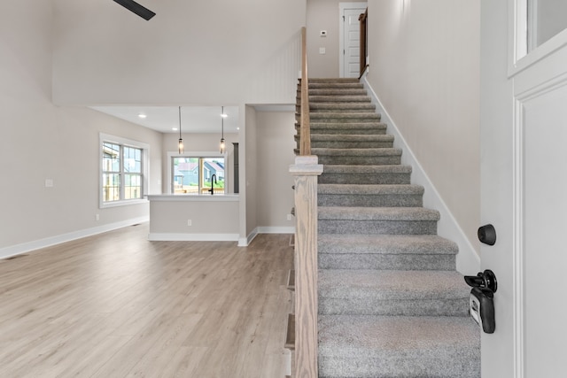 stairs with hardwood / wood-style flooring and sink