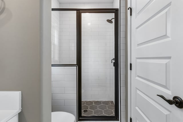 bathroom featuring an enclosed shower and toilet