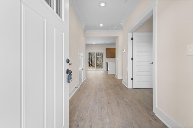 hallway with ornamental molding and light hardwood / wood-style floors