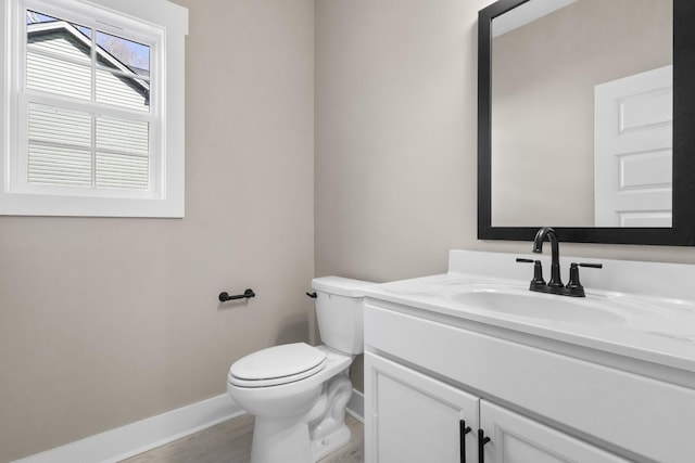 bathroom with hardwood / wood-style flooring, vanity, and toilet