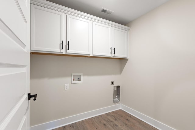 clothes washing area with cabinets, washer hookup, hardwood / wood-style flooring, and hookup for an electric dryer