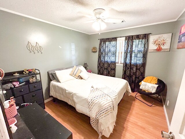 bedroom with crown molding, hardwood / wood-style flooring, a textured ceiling, and ceiling fan