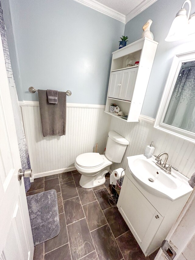 bathroom featuring vanity, toilet, and ornamental molding