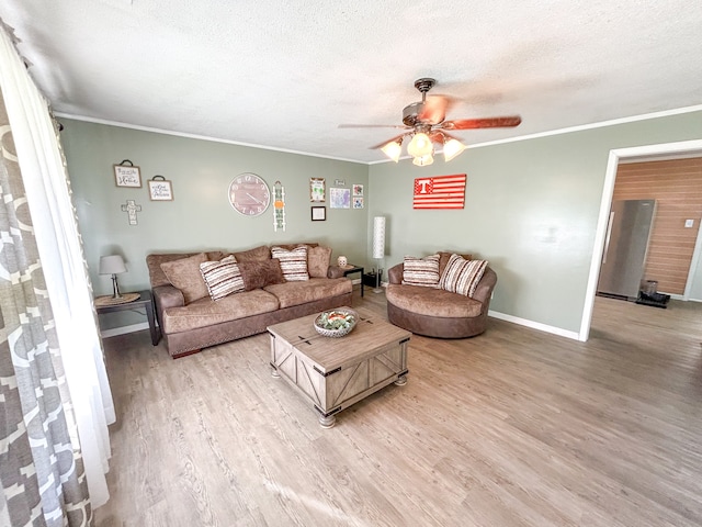 living room with ornamental molding, ceiling fan, light hardwood / wood-style flooring, and a textured ceiling