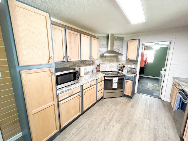 kitchen featuring light brown cabinetry, stainless steel appliances, and wall chimney exhaust hood