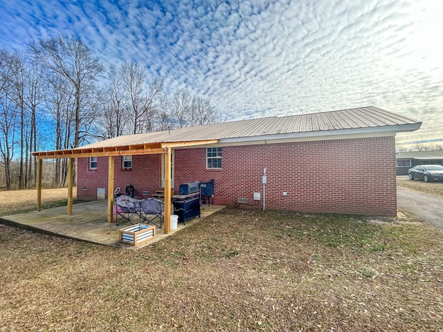 back of house with a patio area and a lawn