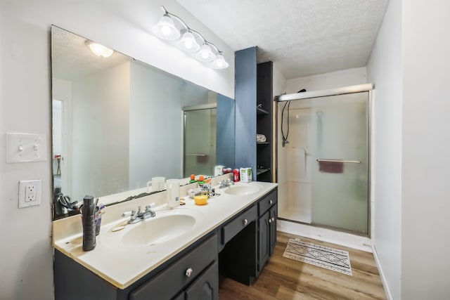 bathroom featuring vanity, a textured ceiling, a shower with door, and hardwood / wood-style flooring