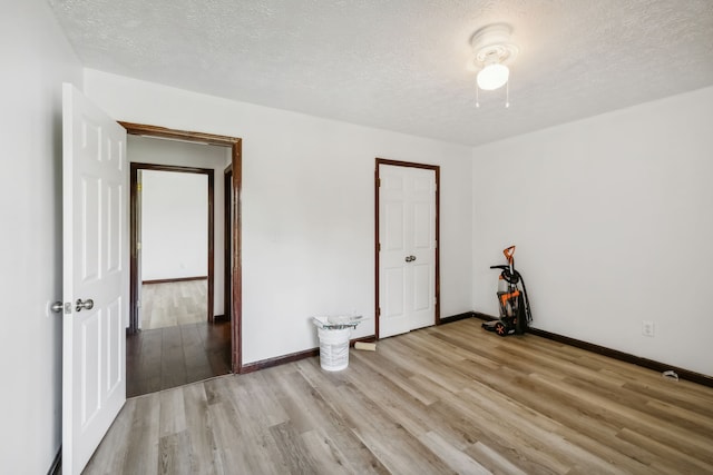 empty room featuring a textured ceiling and light wood-type flooring