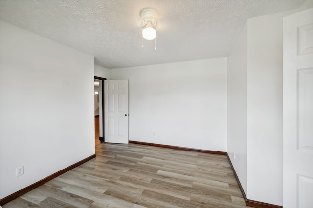 empty room with light hardwood / wood-style flooring and a textured ceiling