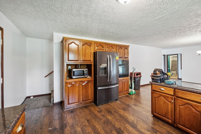 kitchen with dark hardwood / wood-style floors, appliances with stainless steel finishes, and a textured ceiling