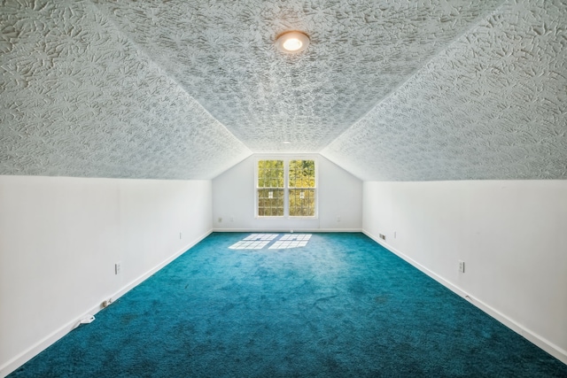 additional living space with a textured ceiling, lofted ceiling, and carpet flooring