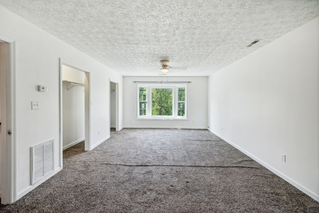 carpeted spare room featuring ceiling fan and a textured ceiling