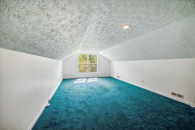 bonus room featuring vaulted ceiling, carpet flooring, and a textured ceiling