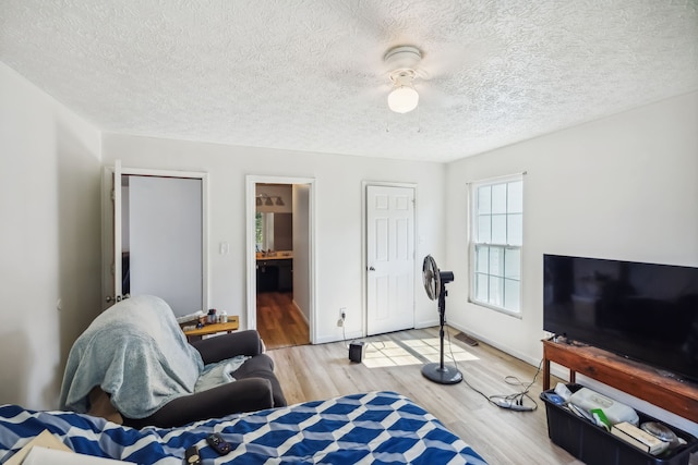 living room with a textured ceiling and light wood-type flooring