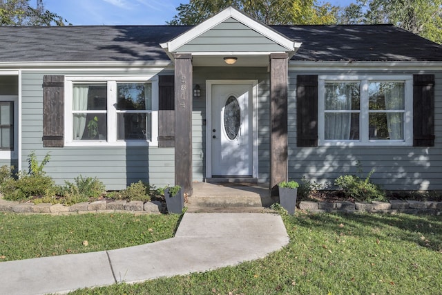 property entrance with a lawn