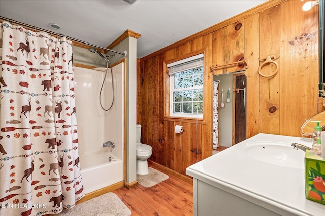 full bathroom with vanity, wooden walls, shower / bath combo with shower curtain, hardwood / wood-style flooring, and toilet