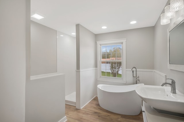 bathroom featuring vanity, wood-type flooring, and shower with separate bathtub