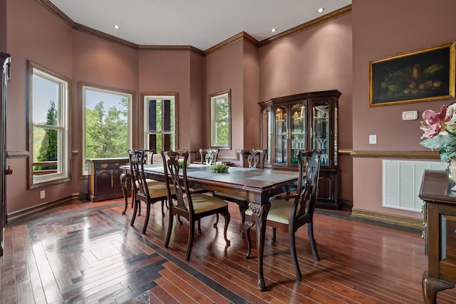 dining area with a towering ceiling, a wealth of natural light, and ornamental molding