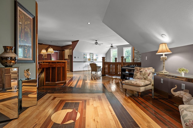 sitting room with ceiling fan, wood-type flooring, and lofted ceiling