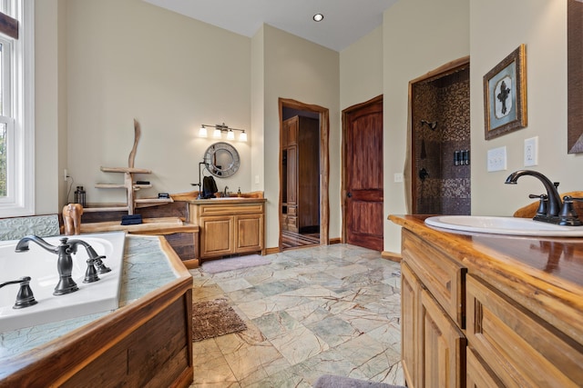 bathroom featuring vanity and independent shower and bath