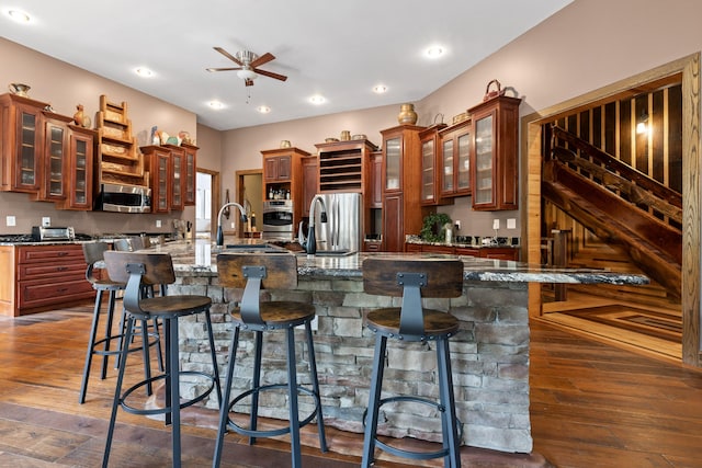 kitchen featuring a large island with sink, a kitchen bar, and dark hardwood / wood-style floors