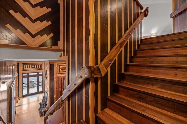 stairway featuring wooden walls