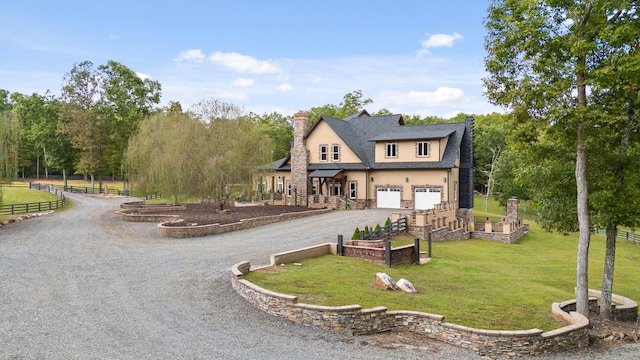 rear view of property featuring a garage and a lawn