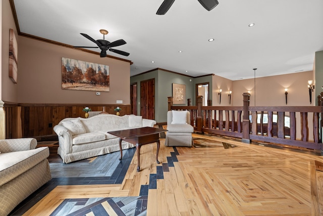 living room featuring ornamental molding, light parquet flooring, and ceiling fan