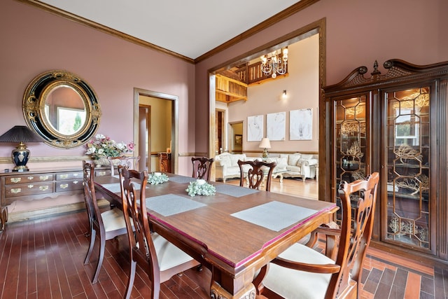 dining space with crown molding, hardwood / wood-style flooring, and a chandelier