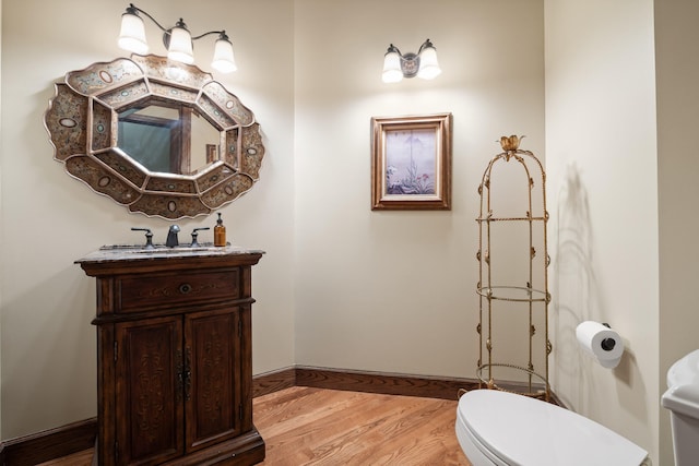 bathroom featuring vanity, toilet, and hardwood / wood-style flooring