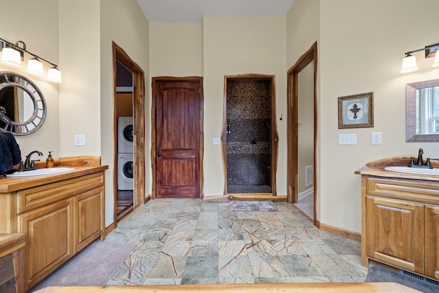 bathroom with vanity, stacked washer / drying machine, and a shower with shower door