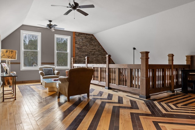 living area with ceiling fan, hardwood / wood-style flooring, and lofted ceiling