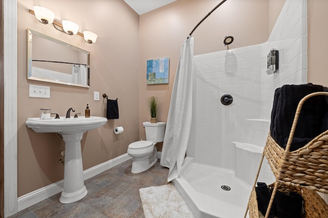 bathroom with toilet, sink, and a shower with curtain