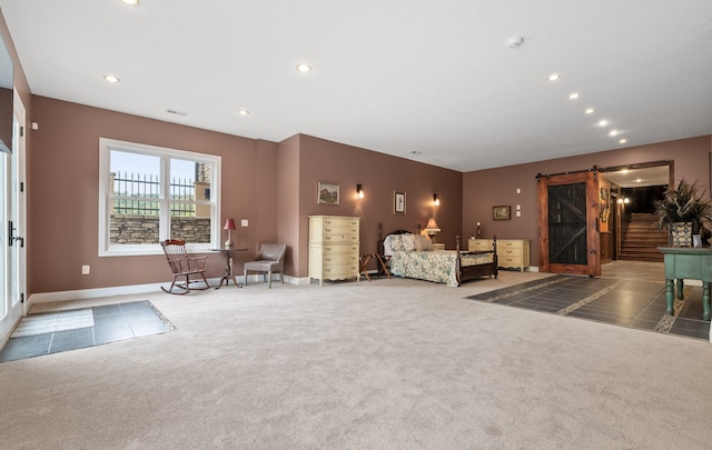 unfurnished bedroom featuring carpet flooring and a barn door