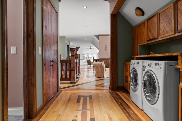 laundry room featuring light hardwood / wood-style flooring, washing machine and clothes dryer, cabinets, and ceiling fan