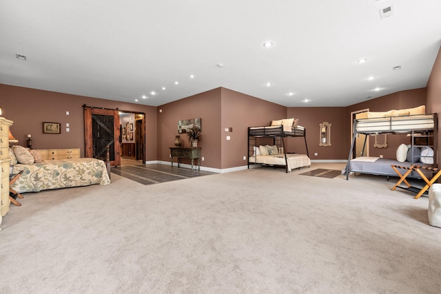 carpeted bedroom with a barn door