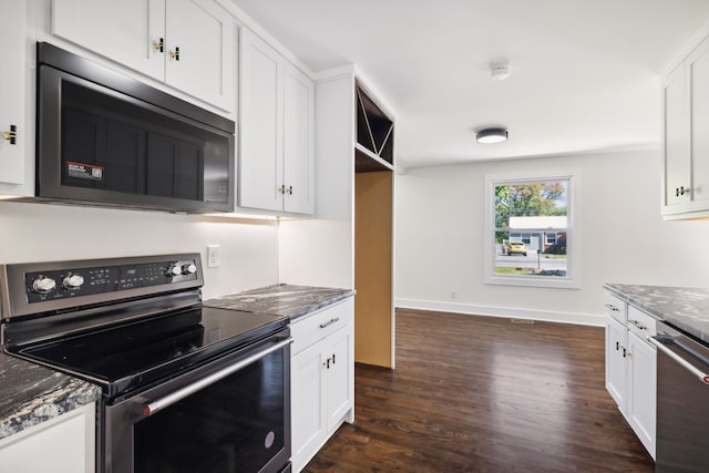 kitchen with white cabinetry, appliances with stainless steel finishes, dark wood-type flooring, and dark stone countertops