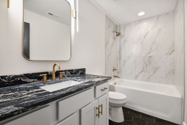 full bathroom featuring tiled shower / bath combo, vanity, tile patterned flooring, and toilet